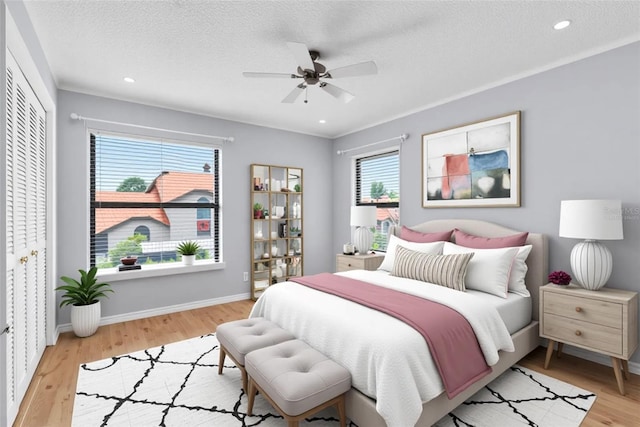 2640 Enterprise Rd E Unit B25, Clearwater, FL 33759 - bedroom featuring light wood-style flooring, a textured ceiling, a ceiling fan, baseboards, and recessed lighting