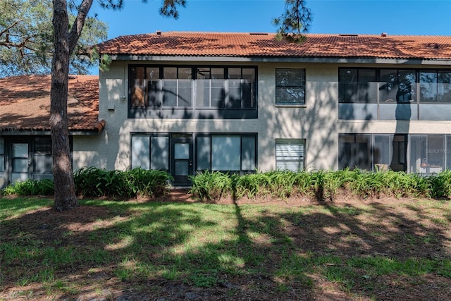 2640 Enterprise Rd E Unit B25, Clearwater, FL 33759 - rear view of house featuring stucco siding, a tiled roof, and a yard