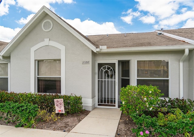 10188 Regent Cir Unit 2802, Naples, FL 34109 - property entrance with stucco siding and roof with shingles