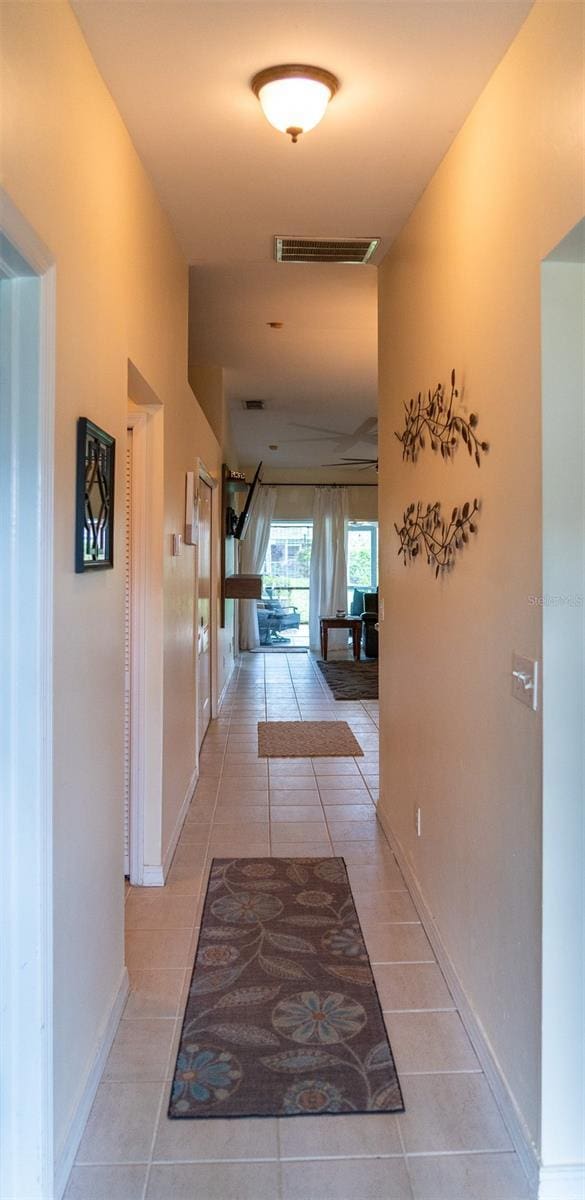 10188 Regent Cir Unit 2802, Naples, FL 34109 - hall featuring light tile patterned flooring and baseboards