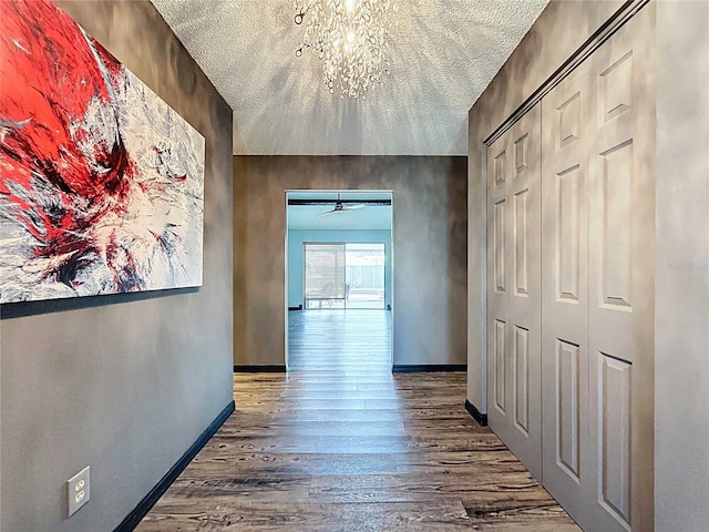 11525 Country Oaks Dr, Tampa, FL 33618 - corridor with wood finished floors, baseboards, and a chandelier