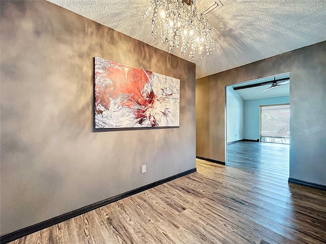 11525 Country Oaks Dr, Tampa, FL 33618 - spare room with wood finished floors, a chandelier, baseboards, and a textured ceiling