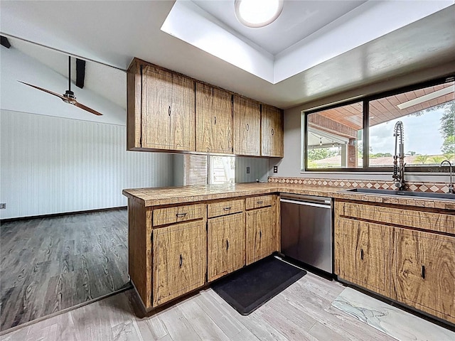 11525 Country Oaks Dr, Tampa, FL 33618 - kitchen with stainless steel dishwasher, a sink, brown cabinetry, and light wood-style flooring