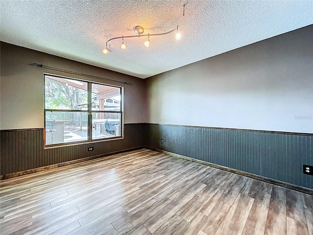 11525 Country Oaks Dr, Tampa, FL 33618 - empty room with wainscoting, wood finished floors, a textured ceiling, and wood walls