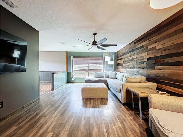 11525 Country Oaks Dr, Tampa, FL 33618 - living area featuring wooden walls, ceiling fan, wood finished floors, a textured ceiling, and baseboards