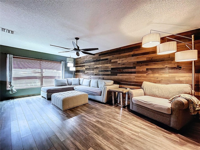 11525 Country Oaks Dr, Tampa, FL 33618 - living room featuring a textured ceiling, wooden walls, a ceiling fan, and wood finished floors