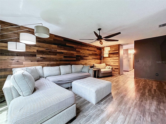 11525 Country Oaks Dr, Tampa, FL 33618 - living area with wood walls, a ceiling fan, wood finished floors, and a textured ceiling