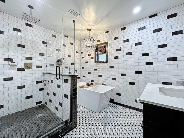 11525 Country Oaks Dr, Tampa, FL 33618 - bathroom featuring a shower stall, a freestanding bath, vanity, a chandelier, and tile walls