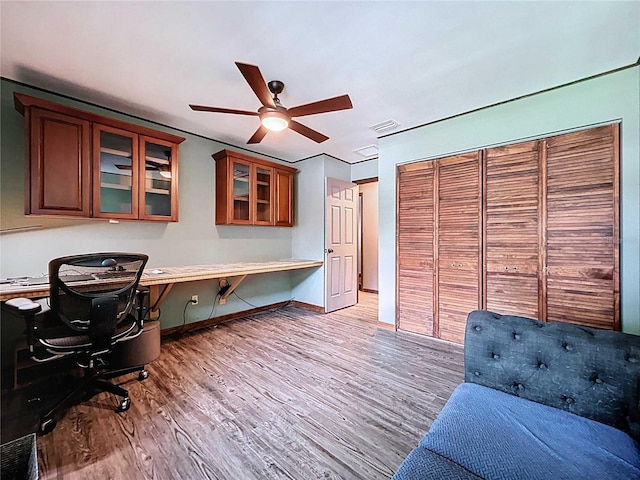 11525 Country Oaks Dr, Tampa, FL 33618 - office area featuring wood finished floors, ceiling fan, built in desk, and baseboards