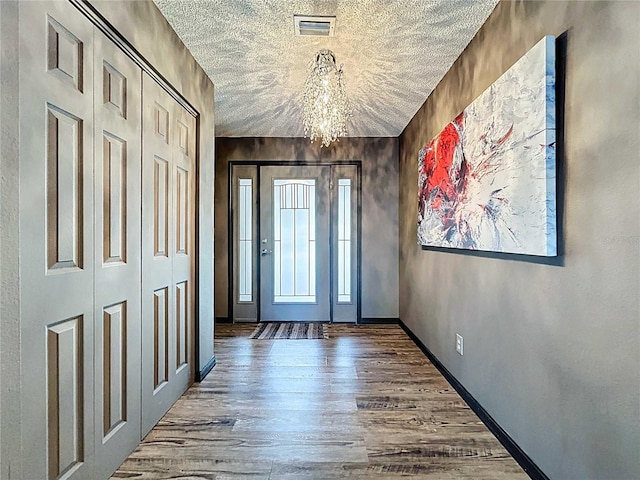 11525 Country Oaks Dr, Tampa, FL 33618 - foyer with wood finished floors, a chandelier, baseboards, and a textured ceiling