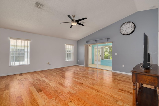 11078 Heathrow Ave, Spring Hill, FL 34609 - unfurnished living room with vaulted ceiling, a ceiling fan, light wood-style flooring, a textured ceiling, and baseboards