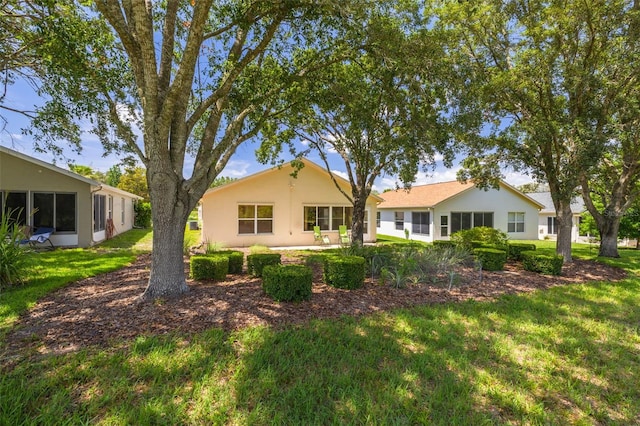 11078 Heathrow Ave, Spring Hill, FL 34609 - back of property featuring a lawn and stucco siding
