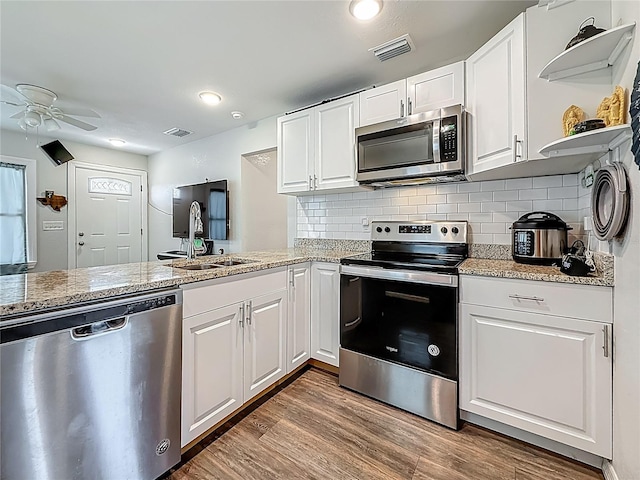 5005 Tangerine Ave S, Gulfport, FL 33707 - kitchen with appliances with stainless steel finishes, open shelves, a sink, a ceiling fan, and white cabinetry
