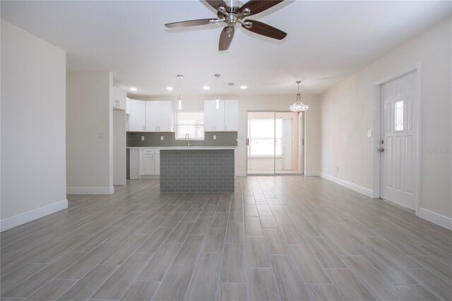 1906 Canterbury Ln Unit 20, Sun City Center, FL 33573 - unfurnished living room featuring light wood-style flooring, ceiling fan, baseboards, a sink, and recessed lighting
