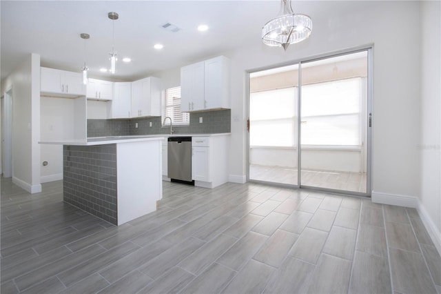 1906 Canterbury Ln Unit 20, Sun City Center, FL 33573 - kitchen featuring dishwasher, white cabinets, tasteful backsplash, wood tiled floors, and a kitchen island