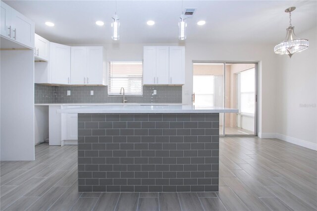 1906 Canterbury Ln Unit 20, Sun City Center, FL 33573 - kitchen with wood finish floors, white cabinetry, backsplash, light countertops, and recessed lighting