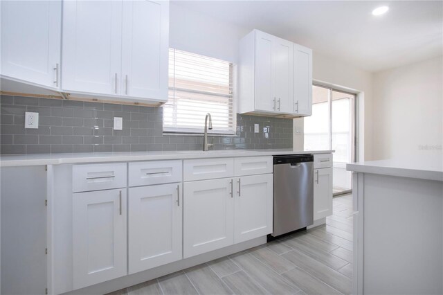 1906 Canterbury Ln Unit 20, Sun City Center, FL 33573 - kitchen with stainless steel dishwasher, light countertops, white cabinets, backsplash, and recessed lighting