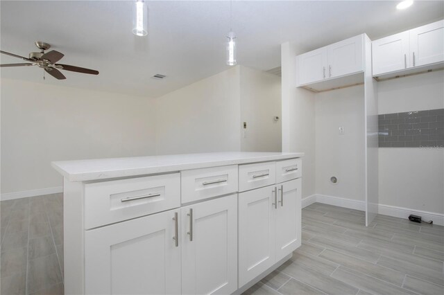1906 Canterbury Ln Unit 20, Sun City Center, FL 33573 - kitchen featuring a ceiling fan, baseboards, hanging light fixtures, light countertops, and white cabinetry