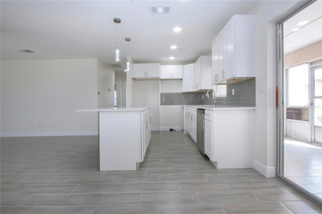 1906 Canterbury Ln Unit 20, Sun City Center, FL 33573 - kitchen featuring stainless steel dishwasher, a sink, wood finish floors, white cabinetry, and recessed lighting