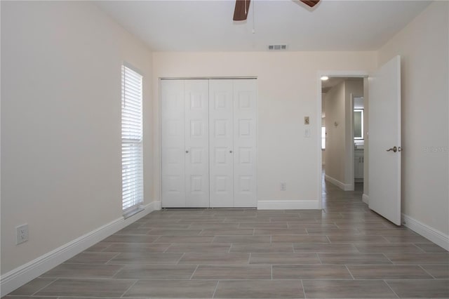1906 Canterbury Ln Unit 20, Sun City Center, FL 33573 - unfurnished bedroom featuring baseboards, wood finished floors, a closet, and a ceiling fan