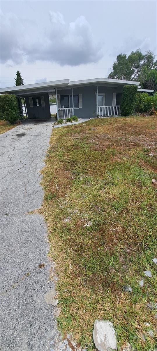 2469 Trade Winds Dr, Dunedin, FL 34698 - ranch-style home featuring a carport and asphalt driveway