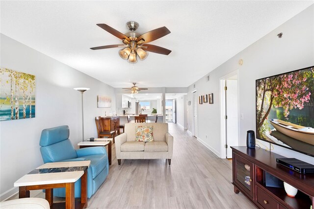 9461 Harbor Greens Way Unit 502, Seminole, FL 33776 - living area with a ceiling fan, light wood finished floors, and baseboards