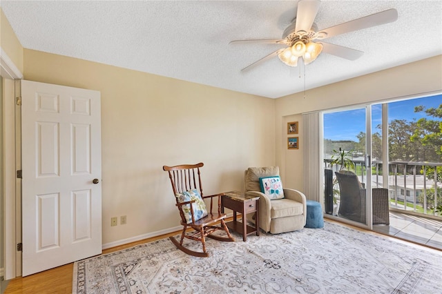 9461 Harbor Greens Way Unit 502, Seminole, FL 33776 - living area featuring ceiling fan, wood finished floors, a textured ceiling, and baseboards