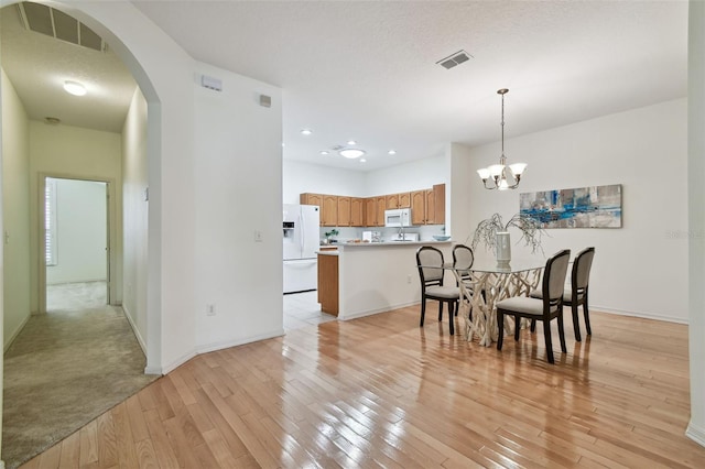 19409 Weymouth Dr, Land O Lakes, FL 34638 - dining area featuring arched walkways, light wood-style flooring, baseboards, a chandelier, and recessed lighting