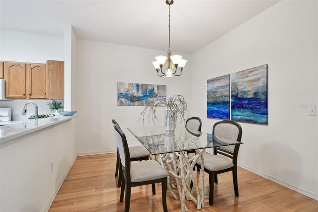 19409 Weymouth Dr, Land O Lakes, FL 34638 - dining room with light wood-type flooring, a chandelier, and baseboards