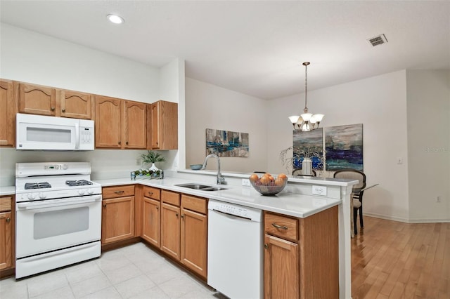 19409 Weymouth Dr, Land O Lakes, FL 34638 - kitchen with white appliances, a sink, a peninsula, a chandelier, and light countertops