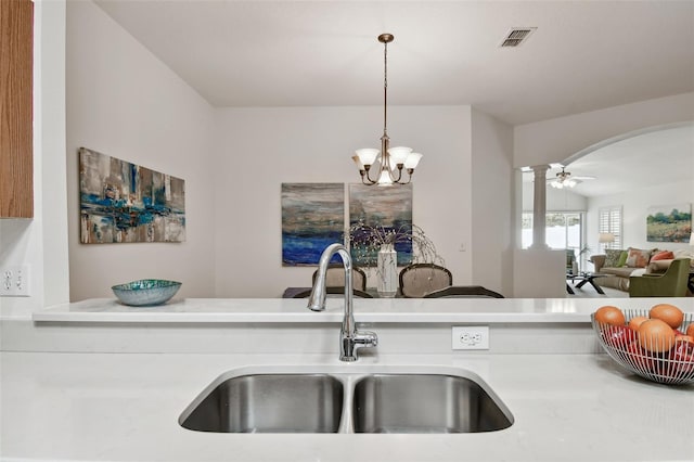 19409 Weymouth Dr, Land O Lakes, FL 34638 - kitchen featuring a sink, arched walkways, light countertops, and pendant lighting
