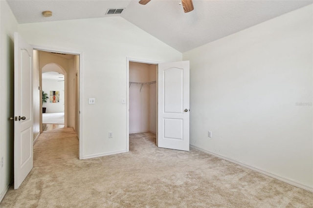 19409 Weymouth Dr, Land O Lakes, FL 34638 - unfurnished bedroom featuring arched walkways, vaulted ceiling, light colored carpet, baseboards, and a spacious closet