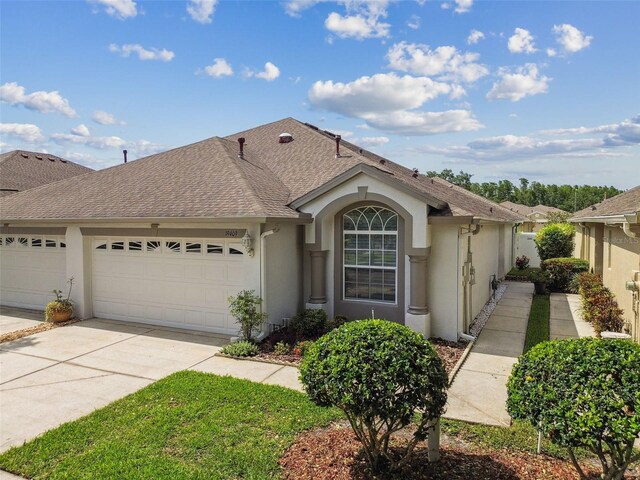 19409 Weymouth Dr, Land O Lakes, FL 34638 - view of front of house featuring a garage, stucco siding, driveway, and roof with shingles