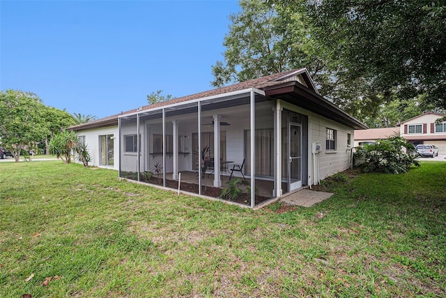 13013 Sawmill Way, Hudson, FL 34667 - rear view of house featuring a lawn, a sunroom, and ceiling fan