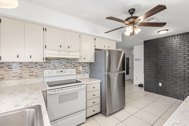 13013 Sawmill Way, Hudson, FL 34667 - kitchen with white electric stove, under cabinet range hood, freestanding refrigerator, light countertops, and a textured ceiling