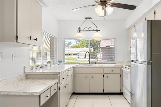 13013 Sawmill Way, Hudson, FL 34667 - kitchen featuring freestanding refrigerator, a sink, electric stove, light countertops, and a textured ceiling