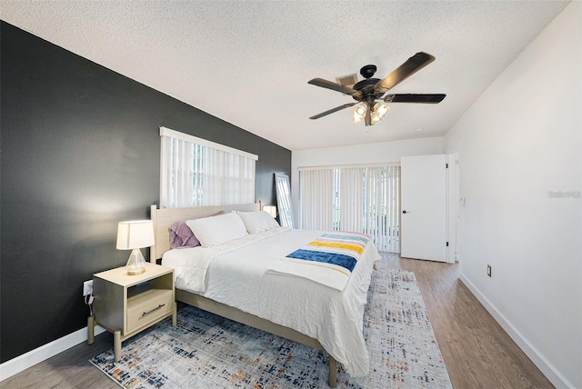 13013 Sawmill Way, Hudson, FL 34667 - bedroom featuring multiple windows, wood finished floors, baseboards, and a textured ceiling