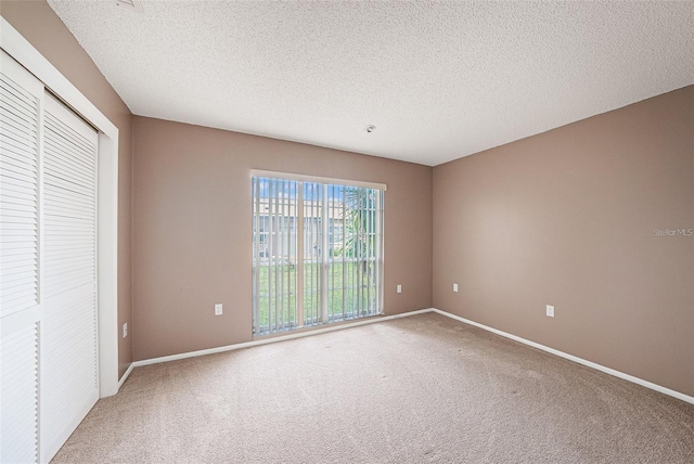 13013 Sawmill Way, Hudson, FL 34667 - unfurnished bedroom with carpet, baseboards, a closet, and a textured ceiling