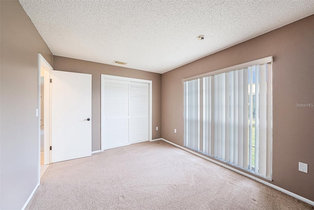 13013 Sawmill Way, Hudson, FL 34667 - unfurnished bedroom with carpet flooring, a closet, a textured ceiling, and baseboards