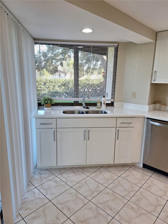 3536 Countrybrook Ln Unit 13, Palm Harbor, FL 34684 - kitchen with stainless steel dishwasher, white cabinets, light tile patterned floors, and light countertops