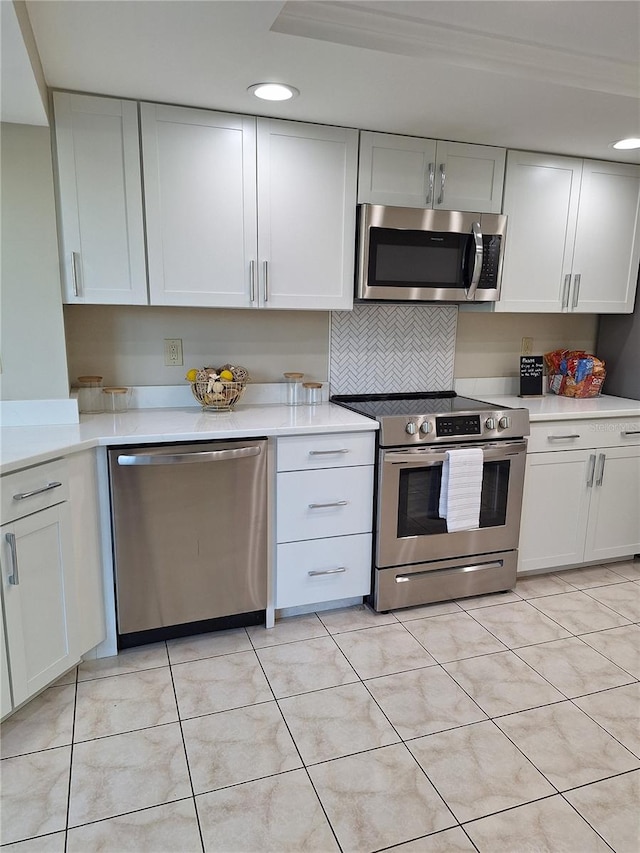 3536 Countrybrook Ln Unit 13, Palm Harbor, FL 34684 - kitchen featuring stainless steel appliances, light countertops, white cabinetry, recessed lighting, and light tile patterned floors