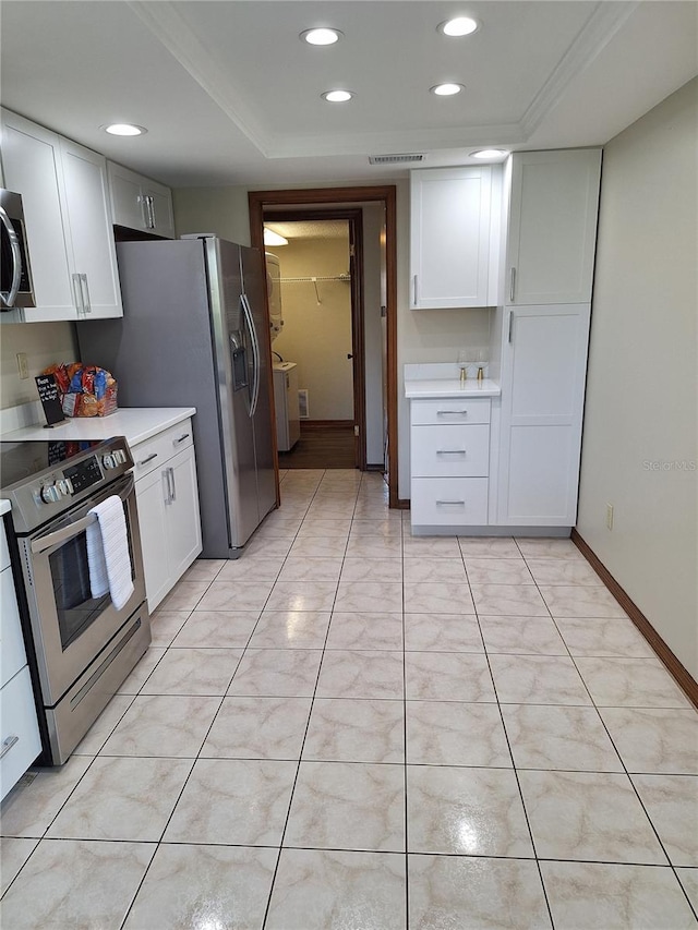 3536 Countrybrook Ln Unit 13, Palm Harbor, FL 34684 - kitchen with stainless steel electric range, light countertops, white cabinets, recessed lighting, and washer / dryer