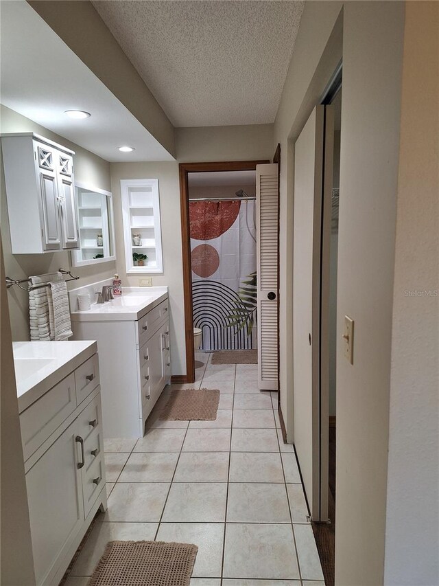 3536 Countrybrook Ln Unit 13, Palm Harbor, FL 34684 - bathroom featuring two vanities, a textured ceiling, tile patterned flooring, and recessed lighting