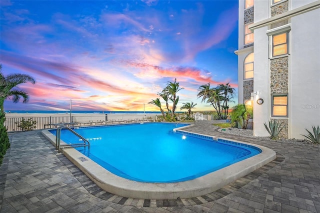 4950 Gulf Blvd Unit 404, St Pete Beach, FL 33706 - pool at dusk featuring a community pool, a water view, and a patio area