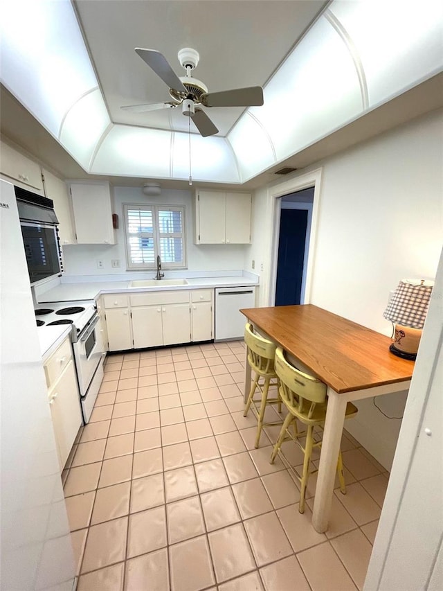 4950 Gulf Blvd Unit 404, St Pete Beach, FL 33706 - kitchen featuring white appliances, light countertops, light tile patterned floors, and a raised ceiling
