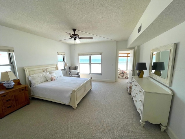 4950 Gulf Blvd Unit 404, St Pete Beach, FL 33706 - bedroom featuring a textured ceiling, light colored carpet, and a ceiling fan