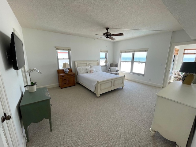 4950 Gulf Blvd Unit 404, St Pete Beach, FL 33706 - bedroom with light colored carpet, a textured ceiling, and ceiling fan