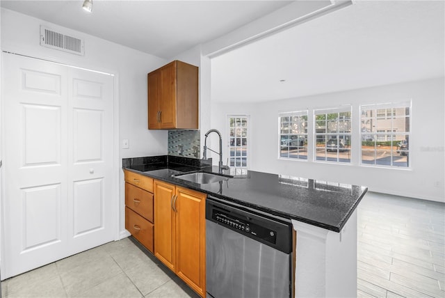 3305 Haviland Ct Unit 101, Palm Harbor, FL 34684 - kitchen with dishwasher, a peninsula, brown cabinets, and dark stone counters