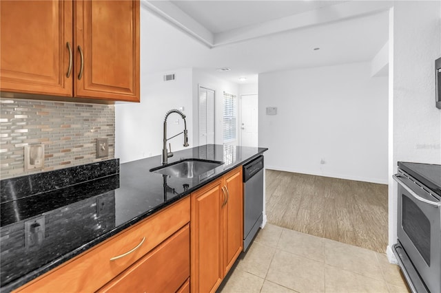 3305 Haviland Ct Unit 101, Palm Harbor, FL 34684 - kitchen with stainless steel appliances, dark stone countertops, tasteful backsplash, brown cabinets, and light wood-type flooring