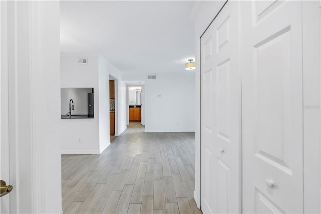 3300 Haviland Ct Unit 103, Palm Harbor, FL 34684 - corridor featuring light wood-style flooring and ornamental molding